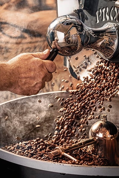 Freshly roasted coffee pouring into a cooling tray