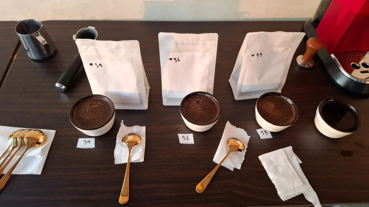 Coffee bags and cupping bowls arranged for a tasting