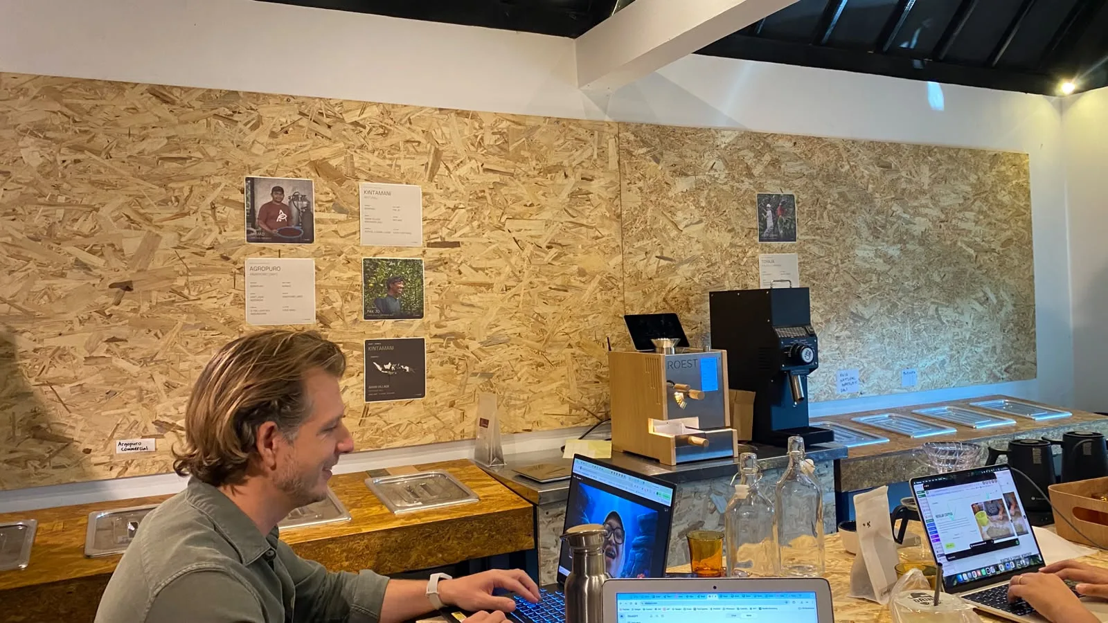 People working at a table beside the coffee roasters