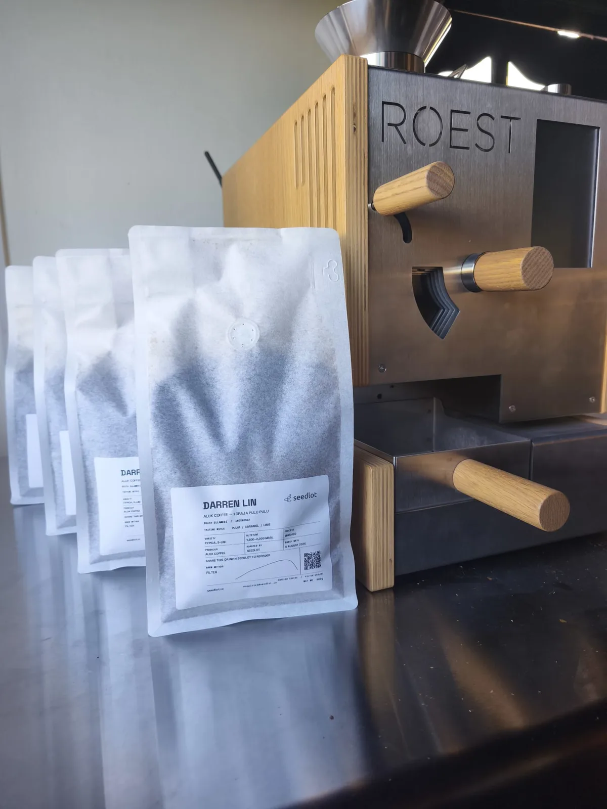 Personalised coffee bags beside the ROEST coffee roaster